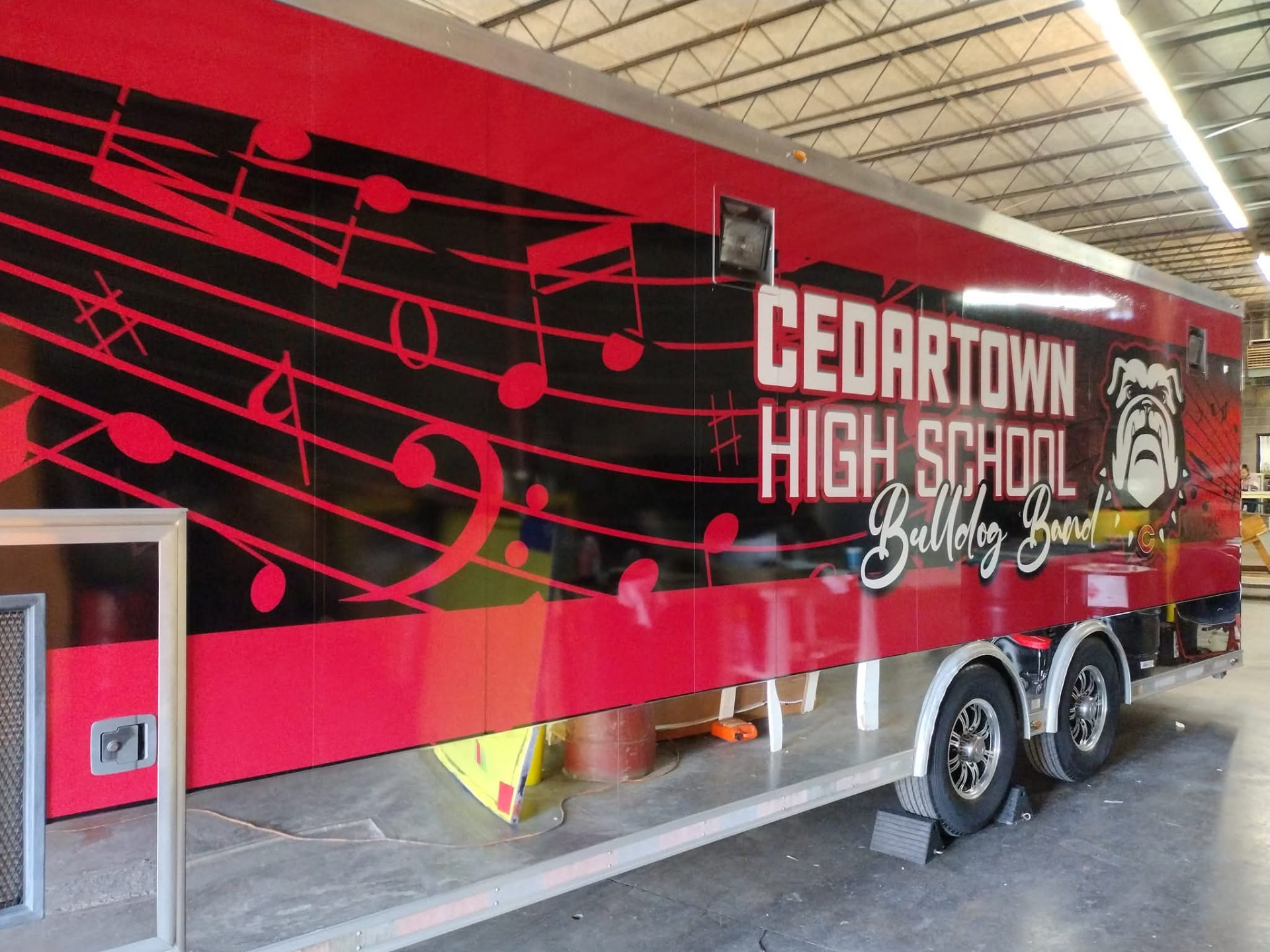 Driver side of the Cedartown High School Bulldog Band trailer wrap with music staff graphics