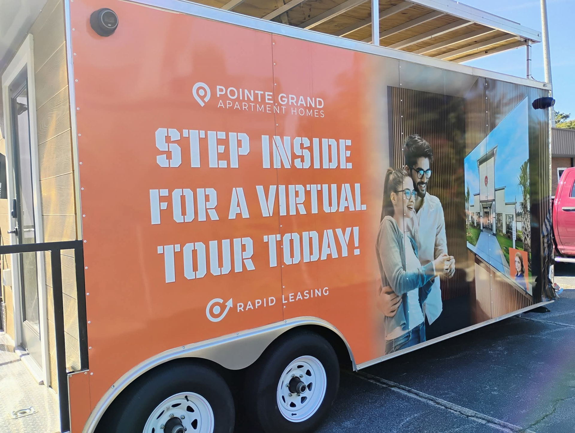 Orange full wrap on a mobile leasing office trailer for Pointe Grand Apartment Homes