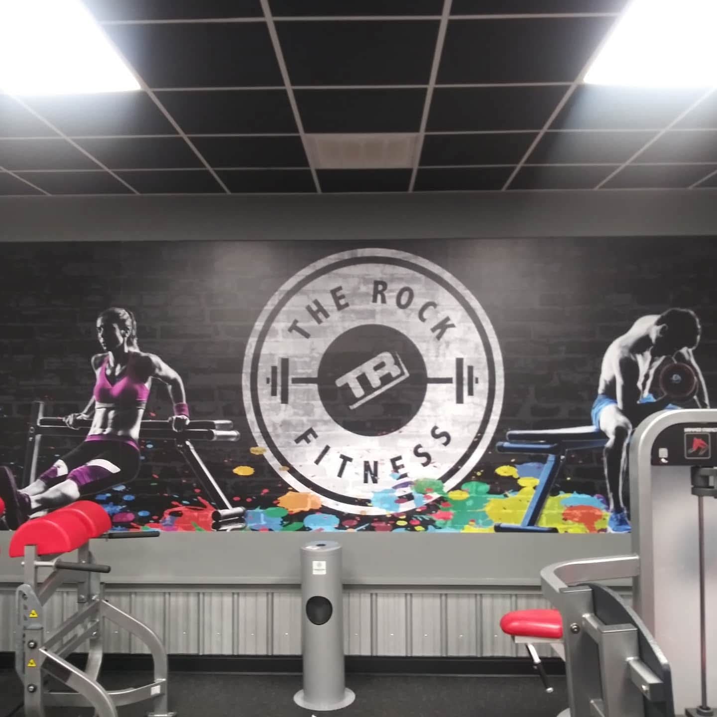 The Rock Fitness wall mural with athletes and paint splatter graphics