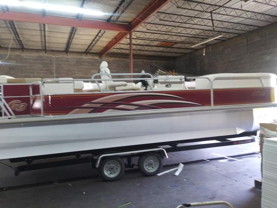 G3 pontoon boat with maroon and tan swoosh vinyl graphics on the fence panels