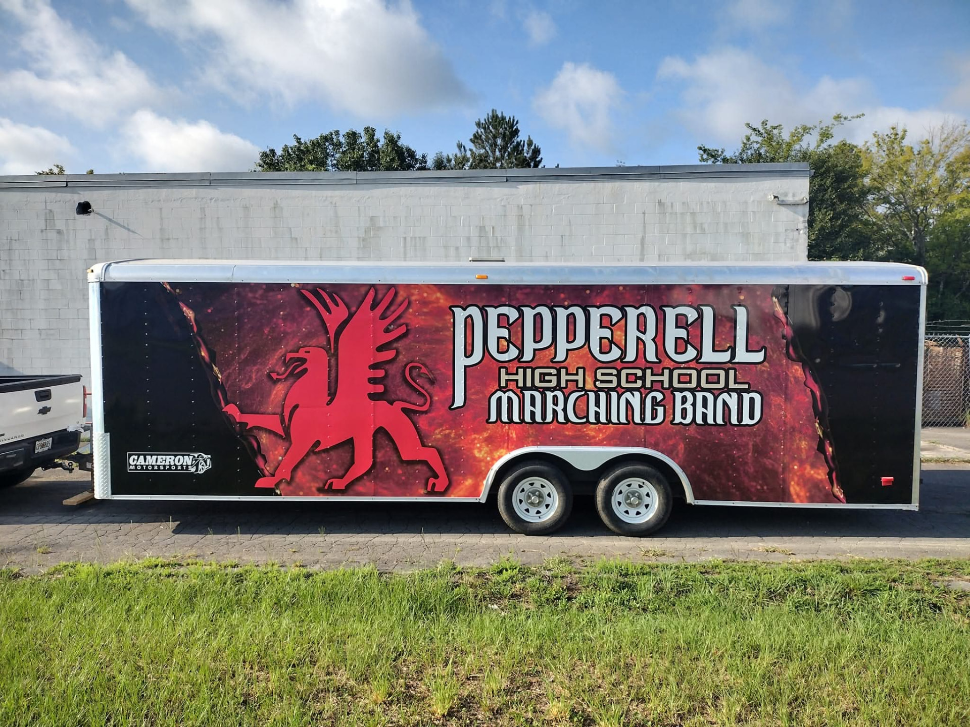 Enclosed trailer wrapped with a red griffin and Pepperell High School Marching Band graphics