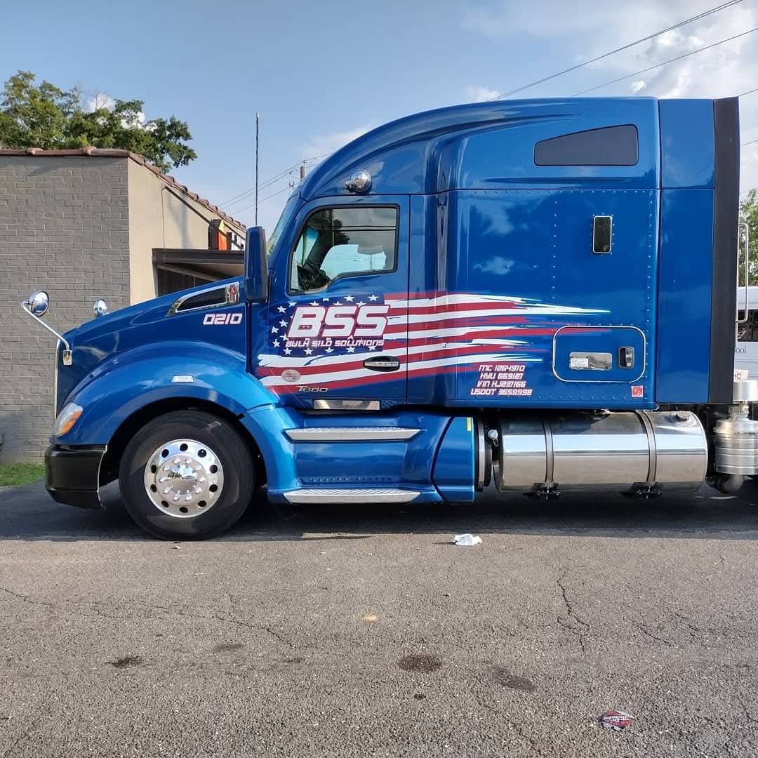 Blue Kenworth sleeper cab with Bulk Silo Solutions flag graphics and DOT numbers