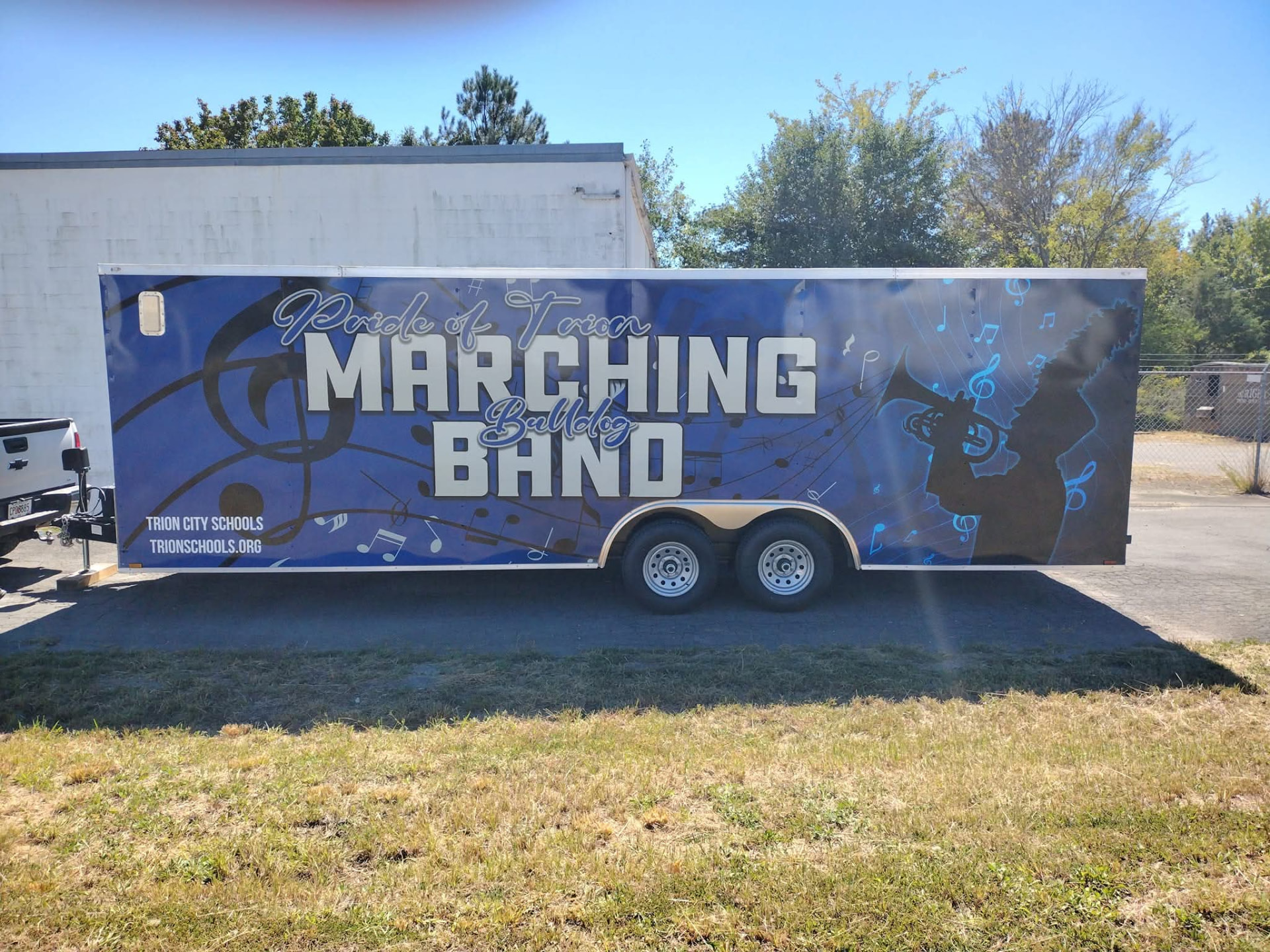 Blue enclosed trailer wrapped with Pride of Trion Marching Bulldog Band graphics