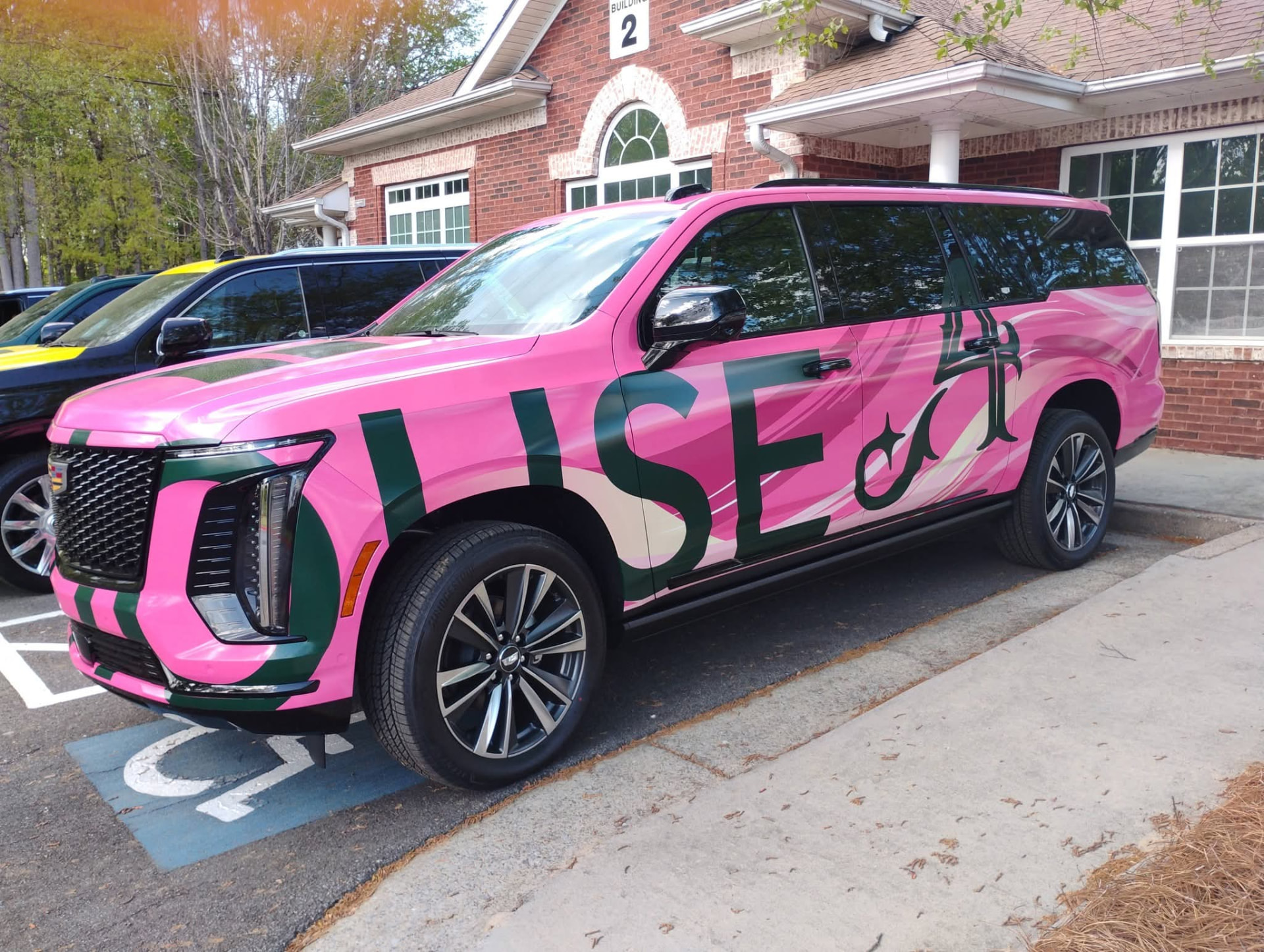 Pink Cadillac Escalade wrapped with Flyhouse Aviation graphics at Augusta Nationals