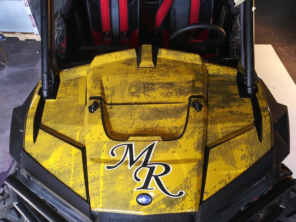 Hood of the Midian Roofing Polaris RZR wrapped in distressed gold with an MR monogram